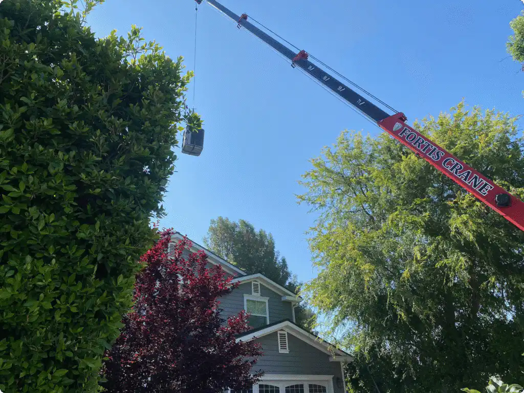 Crane lifting HVAC equipment onto house in Los Angeles.