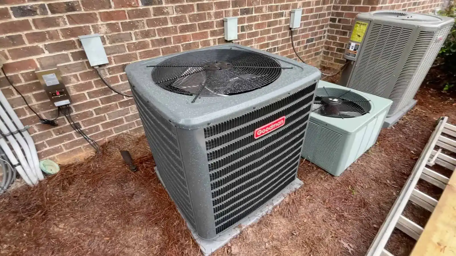 AC unit on a brick wall exterior with electrical connections.