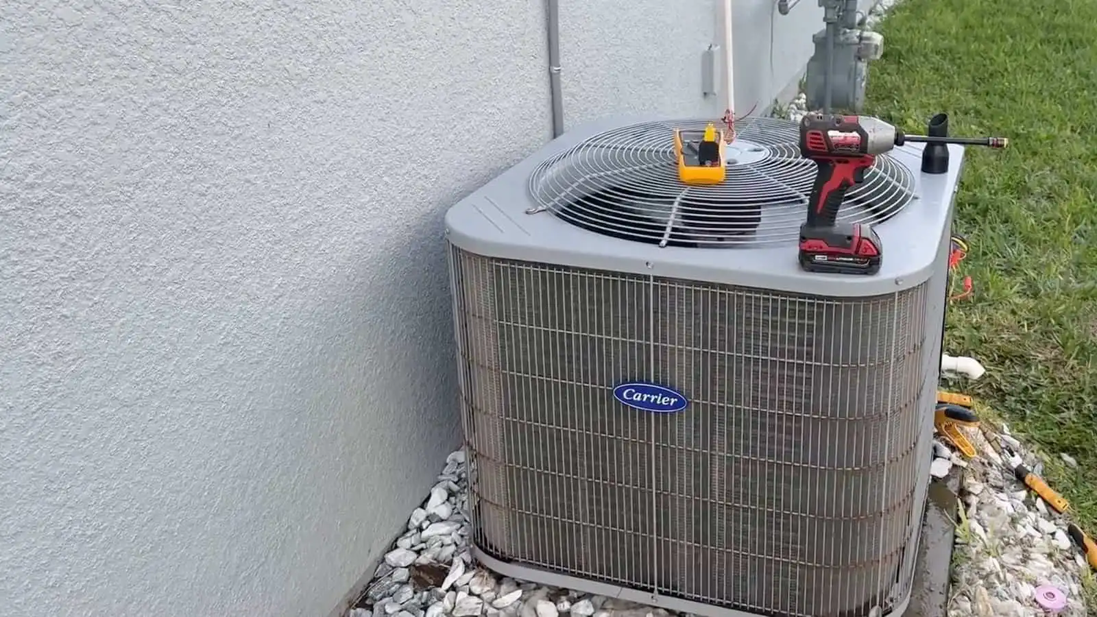 Air conditioning unit with tools on top for servicing or repair.