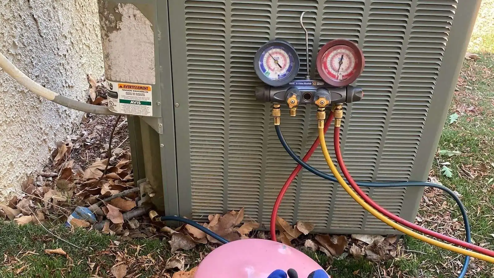 Refrigerant charge being checked with gauges during a leak diagnosis