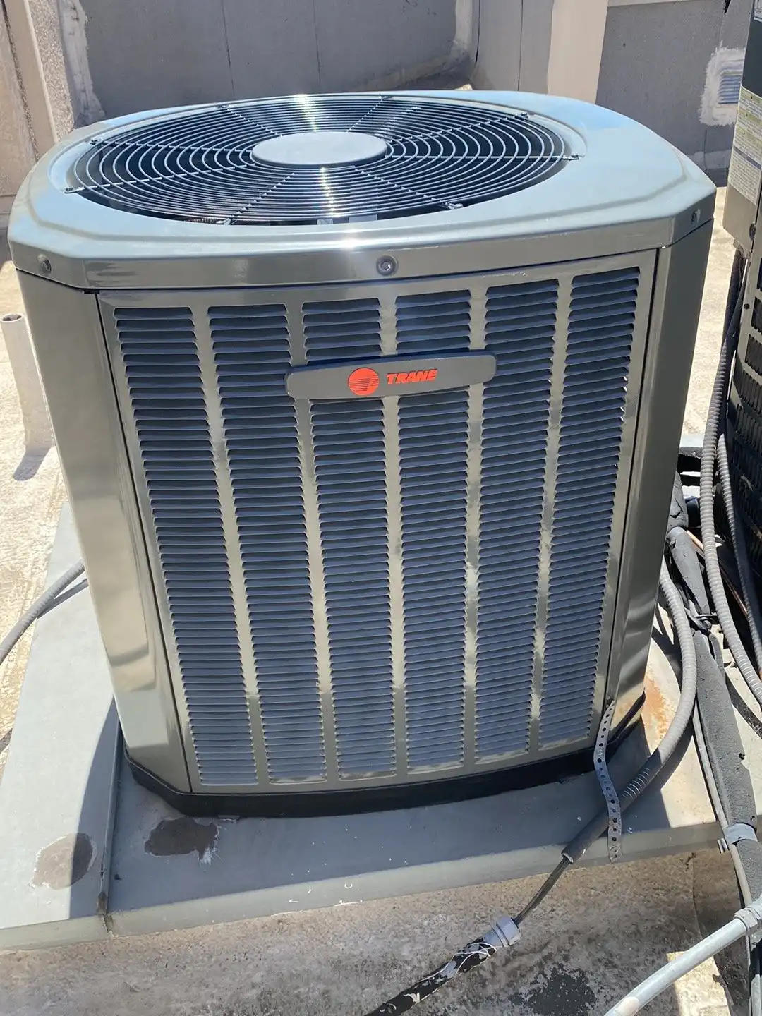 Trane AC condenser on a rooftop pad, one of the major brands we repair