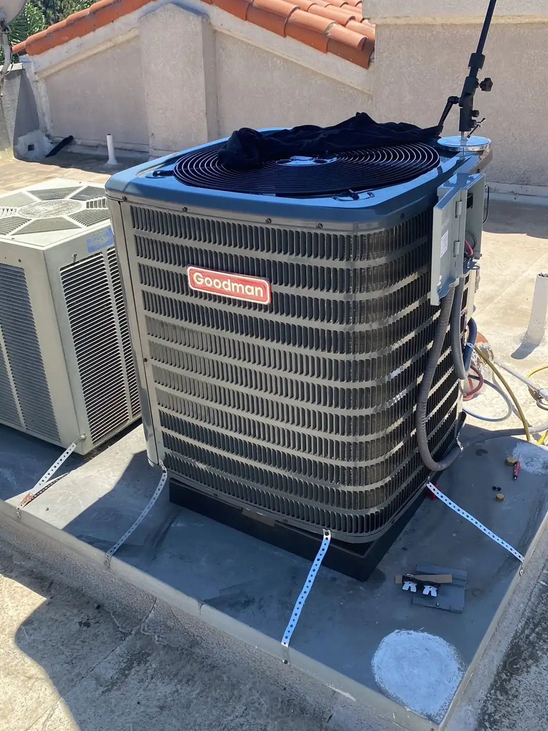 New Goodman AC condenser strapped to its pad after a replacement